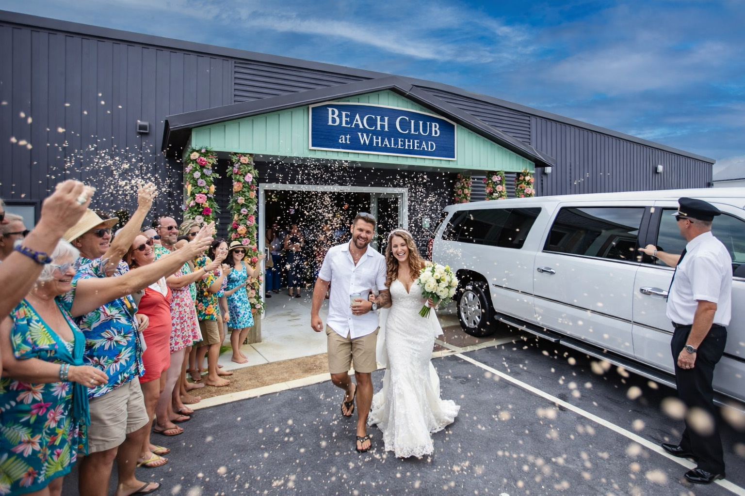 Newlyweds leaving the Beach Club at Whalehead in Corolla NC during a joyful wedding confetti sendoff