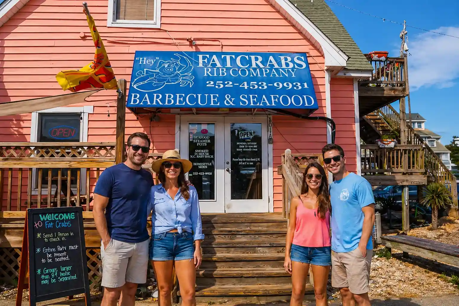 miling group of friends standing outside Fat Crabs Rib Company barbecue and seafood restaurant in Corolla, Outer Banks, North Carolina on a sunny day