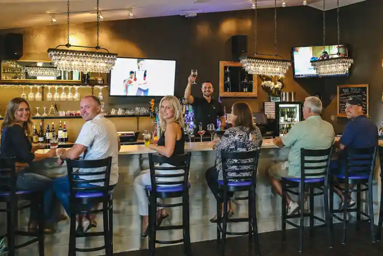 Guests enjoying drinks at the bar inside La Dolce Vita restaurant in the Outer Banks