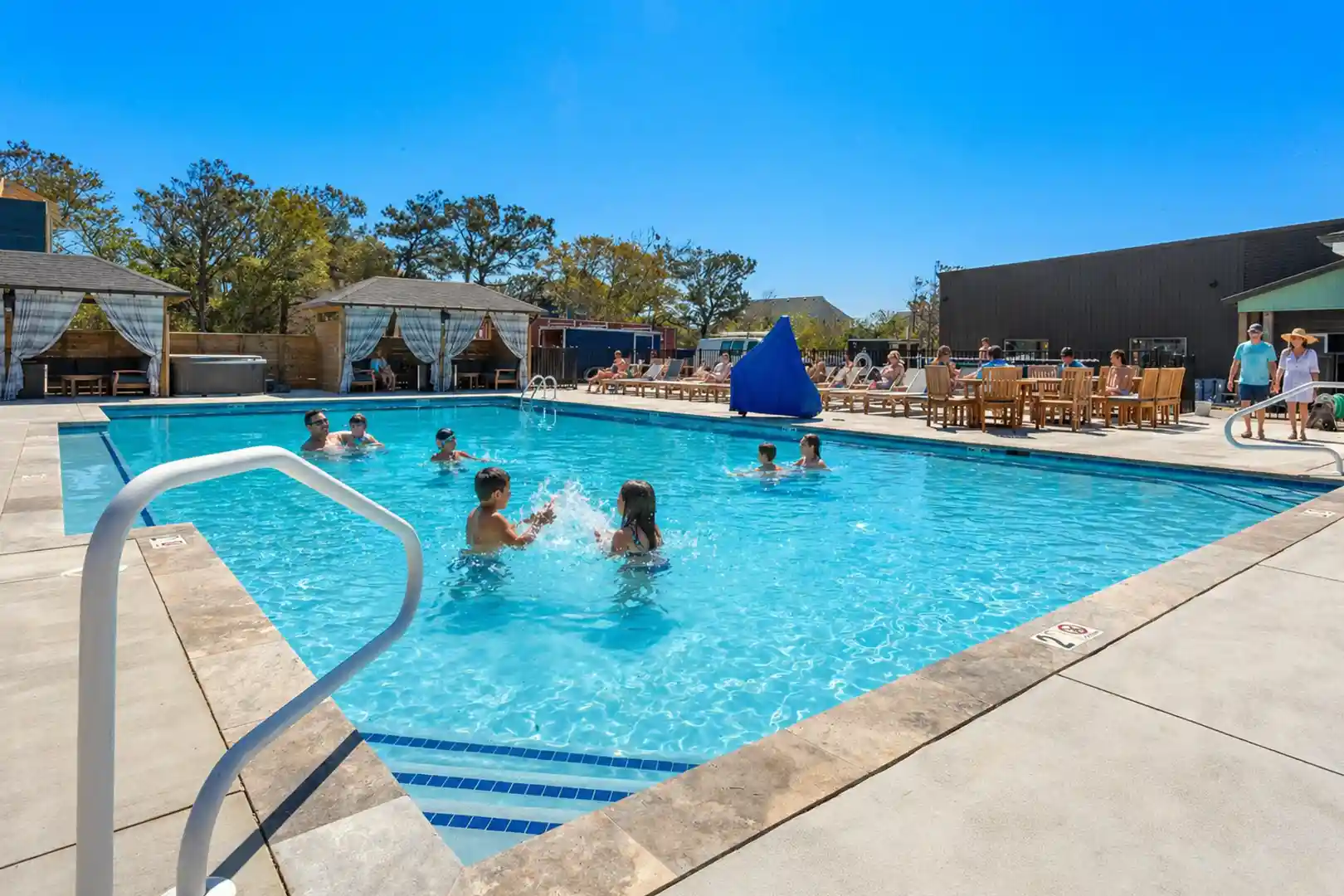 Families swimming and relaxing at Sonoma’s Hideaway community pool with cabanas and lounge chairs