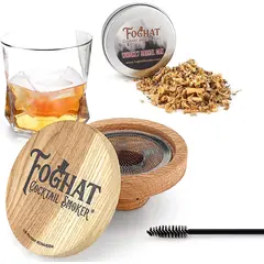 Foghat Cocktail Smoker lid positioned next to bourbon glass and oak smoking chips for product display.