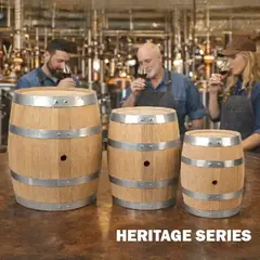 Set of three unfinished American white oak Heritage Series aging barrels with steel hoops displayed on a distillery bar, craft distillers nosing whiskey behind them