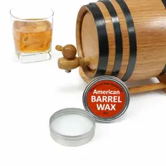 2 oz American Barrel Wax tin next to small oak aging barrel and glass of whiskey, food-safe barrel leak seal wax for repairing barrel seams and preventing spirit evaporation.