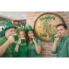 Custom Irish pub barrel sign behind group toasting green beer mugs