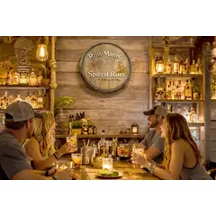 Nautical rum quarter barrel wall sign displayed in tiki bar setting with friends enjoying cocktails.