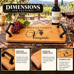 Custom engraved oak vineyard serving tray showing personalized family or vineyard name above an elegant grape cluster and Vineyards design, with sturdy black iron handles and natural oak finish.