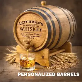 Custom engraved American white oak whiskey aging barrel with black hoops pouring bourbon into a rocks glass, personalized distillery gift barrel for home bar