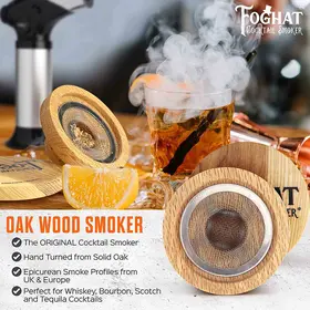 Foghat oak wood cocktail smoker infusing smoke into a whiskey cocktail with orange garnish, designed for bourbon, scotch, and tequila drinks.