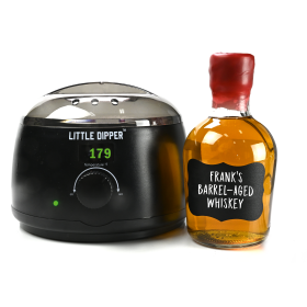 Little Dipper wax warmer next to a finished home-aged whiskey bottle sealed with red bottle wax.
