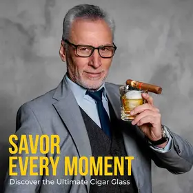 Luxury whiskey cigar glass held by stylish man enjoying bourbon and cigar.