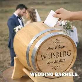 Personalized oak wedding barrel card holder with engraved names and date as guest places card inside, bride and groom blurred in outdoor ceremony background