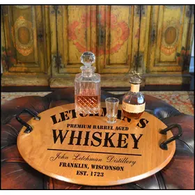 Authentic oak barrel head serving tray with wrought iron handles displaying whiskey decanter and glasses on a rustic bar setup.