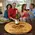 Couples enjoying wine around a personalized barrel head lazy susan centerpiece on a coffee table.