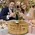 Bride and groom toasting with wine glasses over a personalized wine barrel head lazy susan engraved with names and wedding date, used as a Jewish wedding gift and wine serving centerpiece.