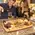 Couple enjoying red wine at home with a personalized oak barrel head serving tray featuring engraved kitchen design, wrought iron handles, cheese, and grapes.