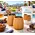 Foghat Charred Oak Whiskey Tumbler Set of Two featuring natural oak wood whiskey glasses with charred interiors, displayed alongside branded gift packaging, a whiskey decanter, and cigar accessories on a luxury outdoor patio at sunset overlooking a scenic golf course and fire pit.