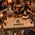 Personalized Drunken Sailor solid oak whiskey serving tray with black wrought iron handles, crystal decanter and bourbon bottle, displayed in an upscale home bar with friends enjoying whiskey.