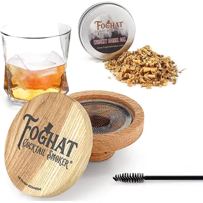Foghat Cocktail Smoker lid positioned next to bourbon glass and oak smoking chips for product display.