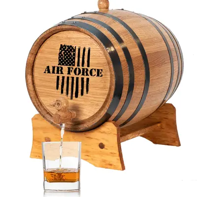Air Force engraved mini oak aging barrel with black steel hoops and wooden stand pouring aged whiskey into glass.