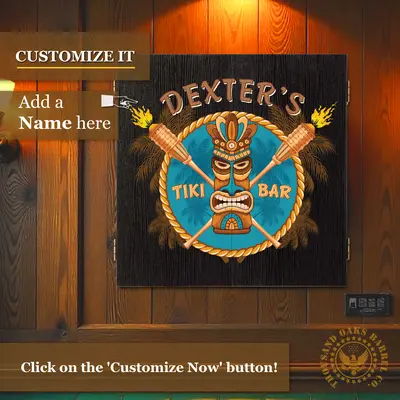 Custom name Tiki Bar dartboard cabinet mounted on wood-paneled wall with “Customize It – Add a Name Here” text overlay for personalized home bar decor.