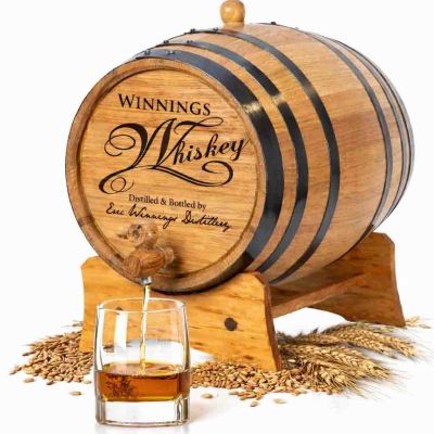 Personalized mini oak whiskey aging barrel made from American white oak with rye and wheat grains and whiskey pouring into glass