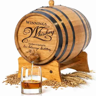 Personalized mini oak whiskey aging barrel made from American white oak with rye and wheat grains and whiskey pouring into glass