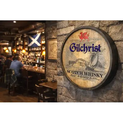 Gilchrist Scotch Whisky round barrel sign mounted on stone wall inside traditional pub setting