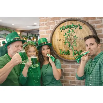 Custom Irish pub barrel sign behind group toasting green beer mugs