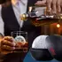 Whiskey being poured over a crystal-clear ice ball made with the Foghat ice sphere mold