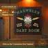 Close-up lifestyle image of a custom dartboard cabinet reading “Maxwell’s Dart Room,” showing a family playing darts in a home game room setting.