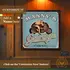 Custom motorcycle garage dartboard cabinet mounted on wall, featuring retro pin-up biker artwork and personalized name design