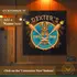 Custom name Tiki Bar dartboard cabinet mounted on wood-paneled wall with “Customize It – Add a Name Here” text overlay for personalized home bar decor.