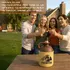 Group of friends outdoors raising shot glasses beside a Firewater moonshine jug with a dragon logo, highlighting vintage two-tone ceramic design and Americana craftsmanship.
