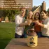 Friends toasting drinks outdoors with a mermaid moonshine jug on the table, emphasizing vintage Americana décor and humorous rum-themed bar accessories.