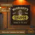 Personalized Western Saloon dartboard cabinet mounted on wood wall with custom name design and vintage rustic bar decor styling.