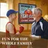 Grandfather and grandson playing darts in front of personalized Fight Club dartboard cabinet in game room