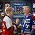 Grandfather and grandson enjoying a personalized hockey dartboard cabinet in a sports-themed game room.