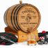 Mini oak Scotch whisky barrel with engraved Scottish bagpiper design displayed with tartan fabric and traditional accessories.