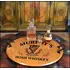 21-inch round authentic oak barrel head serving tray with wrought iron handles displaying Irish whiskey decanter and glass in a rustic bar setting.